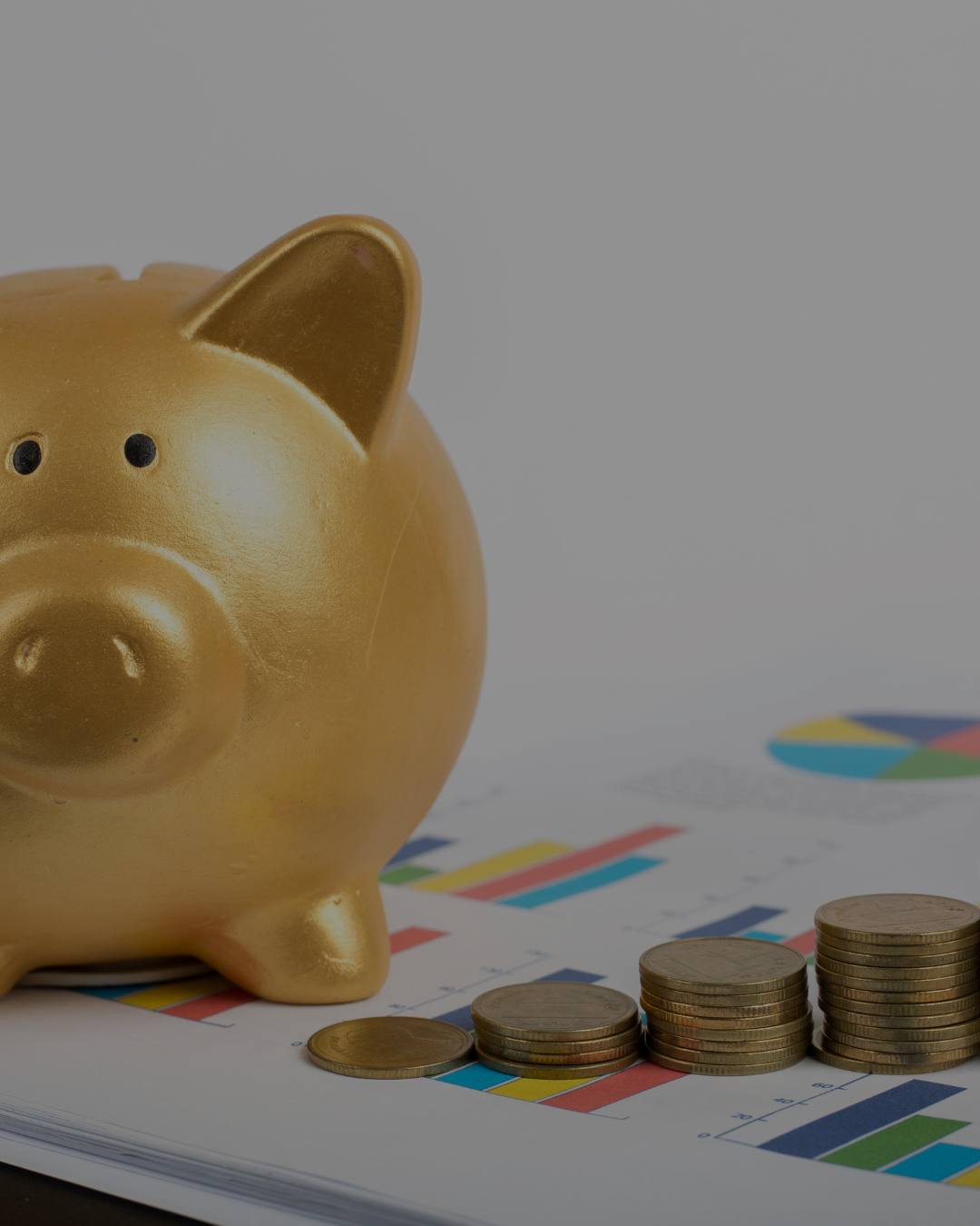 Gold piggy bank and coins on a financial chart